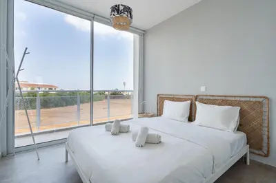 a bedroom with a large white bed with towels on it at Blu Horizon - Stylish Living with Pool & Balconies in Protaras in Paralimni