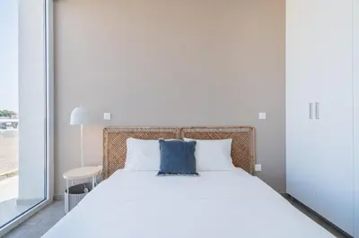 a bedroom with a large bed with a blue pillow at Blu Horizon - Stylish Living with Pool & Balconies in Protaras in Paralimni