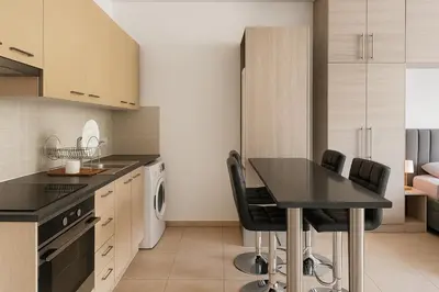 a kitchen with a black table and black chairs at Maison Amalthea in Limassol