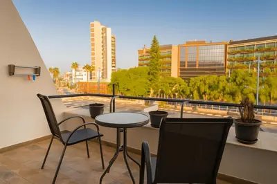 a balcony with a table and chairs and a view of a city at Maison Amalthea in Limassol