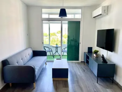 a living room with a couch and a tv and a table at Fully Equipped One Bedroom APT in Limassol