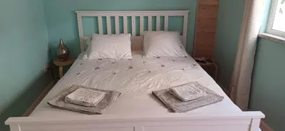 a white bed with two towels on top of it at Jay's Nest in Larnaka