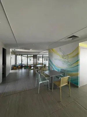 a room with tables and chairs and a painting on the wall at AppleGym sports centre in Laxia
