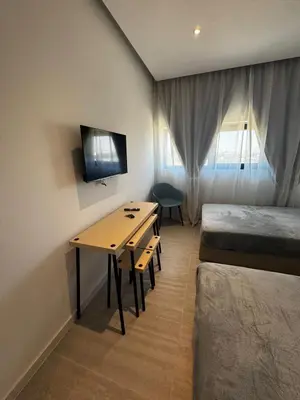 a room with a desk and a bedroom with a bed at AppleGym sports centre in Laxia
