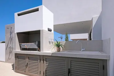 a white kitchen with a sink and a counter at Princess Zena Luxury Villa - Large Pool in Protaras