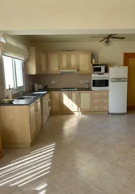a kitchen with wooden cabinets and a white refrigerator at Sunrise Beach Club, Bogaz, North Cyprus in Boğaz