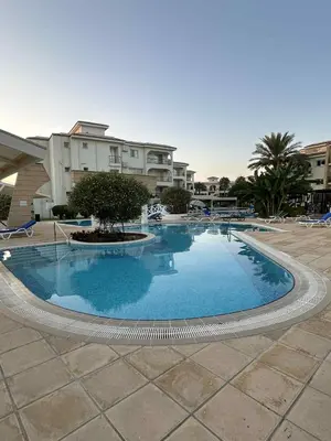 a large swimming pool with a tree in the middle at Sunrise Beach Club, Bogaz, North Cyprus in Boğaz