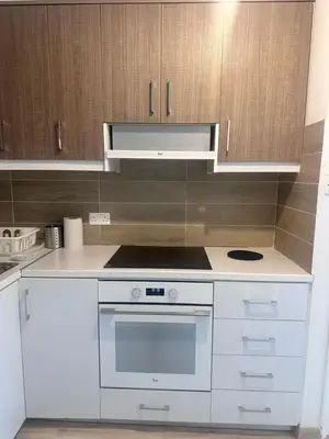 a kitchen with white cabinets and a stove top oven at Faneromeni 33 in Scala