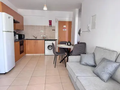 a living room with a couch and a table in a kitchen at Fresh & Cozy-close to the beach in Paralimni
