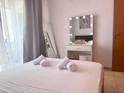 a bedroom with a white bed with towels on it at Fresh & Cozy-close to the beach in Paralimni