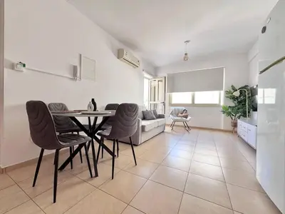 a living room with a table and chairs and a couch at Fresh & Cozy-close to the beach in Paralimni