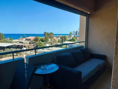 a balcony with a couch and a view of the ocean at ERIKA Sea Breeze Makenzie in Larnaka