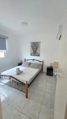 a bedroom with a bed in a white room at ERIKA Sea Breeze Makenzie in Larnaka
