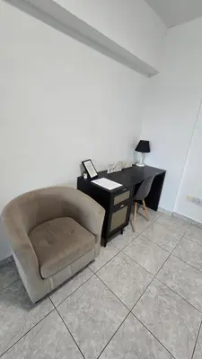 a living room with a chair and a desk at ERIKA Sea Breeze Makenzie in Larnaka