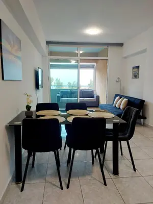 a living room with a table and chairs and a couch at ERIKA Sea Breeze Makenzie in Larnaka