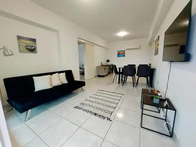a living room with a black couch and a table at ERIKA Sea Breeze Makenzie in Larnaka