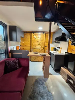 a living room with a red couch and a kitchen at Chardonnay Tiny Home for Nature Lovers North Cyprus in Kérynia