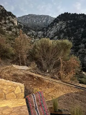 a blanket sitting on a ledge with mountains in the background at Chardonnay Tiny Home for Nature Lovers North Cyprus in Kérynia