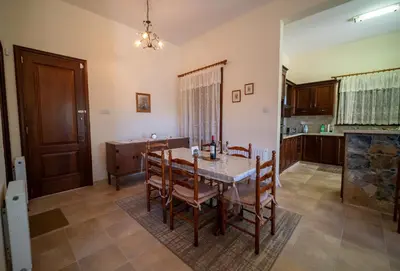 a kitchen and dining room with a table and chairs at Casa Harmonia Traditional Stone House, Escape to Silence Soul and Serenity in Nature with 2 Bedrooms, Fireplace and Mountain Breeze in Mandria