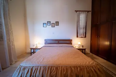 a bedroom with a large bed with two side tables at Casa Harmonia Traditional Stone House, Escape to Silence Soul and Serenity in Nature with 2 Bedrooms, Fireplace and Mountain Breeze in Mandria