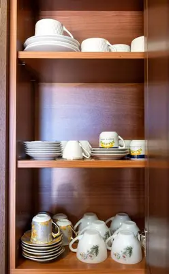 a cabinet filled with dishes and cups and plates at Casa Harmonia Traditional Stone House, Escape to Silence Soul and Serenity in Nature with 2 Bedrooms, Fireplace and Mountain Breeze in Mandria