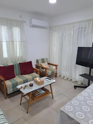 a living room with a couch and a tv at The Heart of Moutoullas in Moutoullas