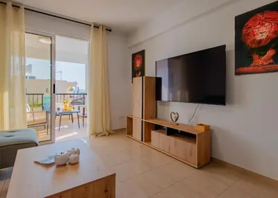 a living room with a flat screen tv on a wall at TelMar Sunrise View 100m from the Sea in Larnaka