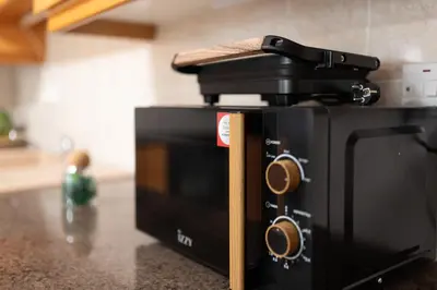 a black toaster oven sitting on top of a counter at TelMar Sunrise View 100m from the Sea in Larnaka