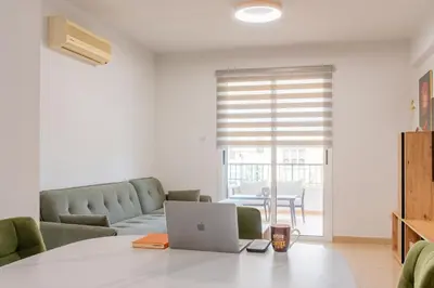 a living room with a couch and a laptop on a table at TelMar Sunrise View 100m from the Sea in Larnaka