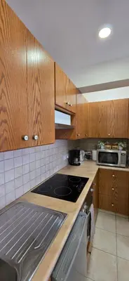 a kitchen with wooden cabinets and a stove top oven at CrisMari Napa in Ayia Napa