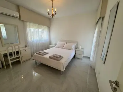a bedroom with a white bed and a chandelier at Sfina Sea view apartment by Ezoria villas in Limassol