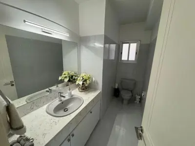 a bathroom with a sink and a mirror and a toilet at Sfina Sea view apartment by Ezoria villas in Limassol