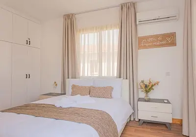 a bedroom with a white bed and a window at TelMar Royal Villa Sea View in Mazotos