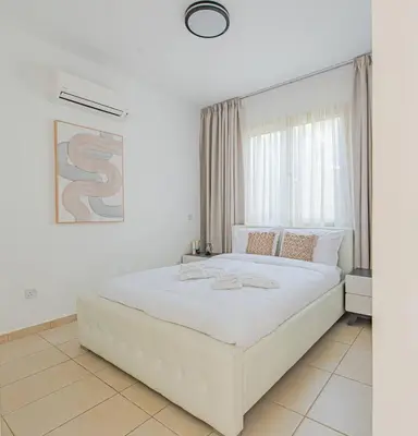 a bedroom with a large white bed with a large window at TelMar Royal Villa Sea View in Mazotos