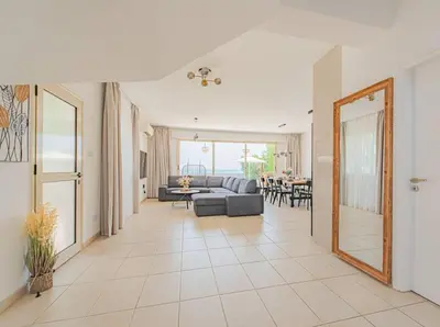 a living room with a couch and a table at TelMar Royal Villa Sea View in Mazotos