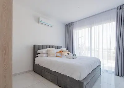 a bedroom with a large bed with a large window at TelMar Sea View - 2 min walk to the Beach in Voroklini