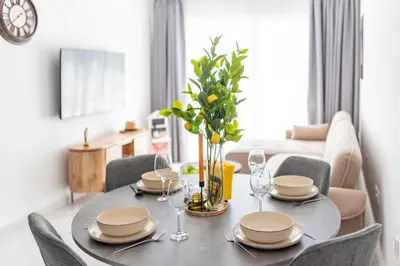 a dining room table with plates and glasses on it at TelMar Sea View - 2 min walk to the Beach in Voroklini
