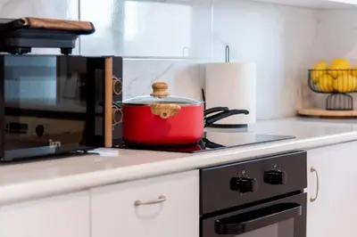a red pot sitting on top of a stove in a kitchen at TelMar City - Harbour Sea View from the Veranda in Larnaka