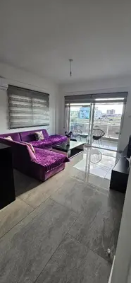 a living room with a purple couch and a glass table at Modern apartment in North Nicosia