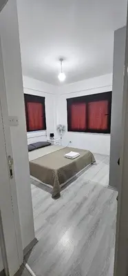 a bedroom with a bed and two large windows at Modern apartment in North Nicosia