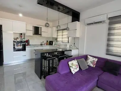 a living room with a purple couch in a kitchen at Modern apartment in North Nicosia