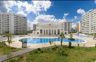 a large building with a swimming pool in front of it at Caesar Resort Spa Long Beach