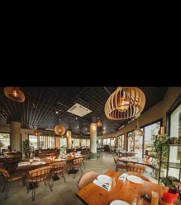 a restaurant with wooden tables and chairs and chandeliers at Caesar Resort Spa Long Beach