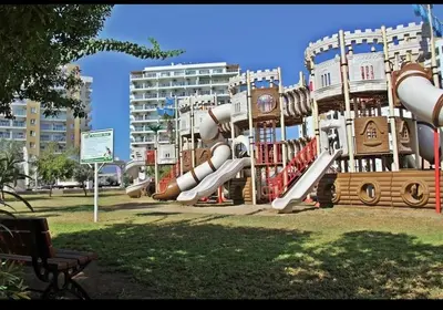 a playground with a slide in a park at Caesar Resort Spa Long Beach
