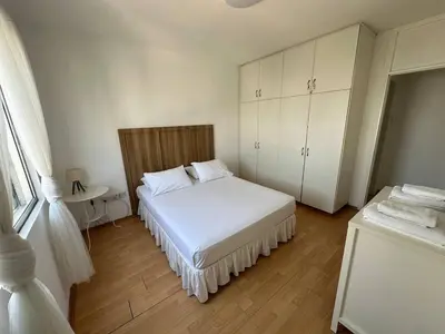 a small bedroom with a white bed and white cabinets at Suite 52 - Two Bedroom Apartment with Shared Pool in Nicosia