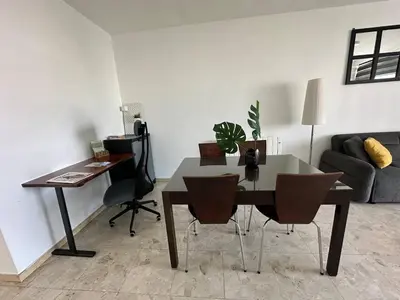 a living room with a desk and a table and chairs at Suite 52 - Two Bedroom Apartment with Shared Pool in Nicosia