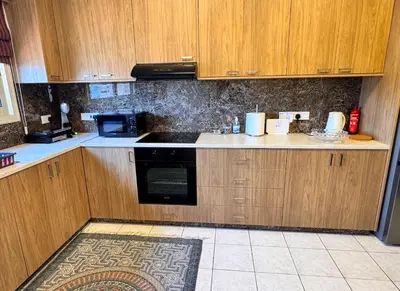 a kitchen with wooden cabinets and a stove top oven at Family House in Limassol