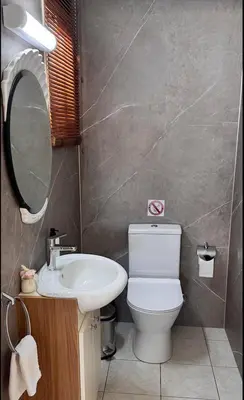 a bathroom with a white toilet and a sink at Family House in Limassol