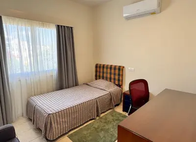 a bedroom with a bed and a desk and a window at Family House in Limassol