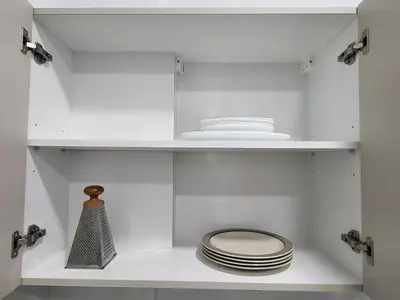 a white cabinet with a toilet and plates on it at Chryso Apts Protaras in Paralimni